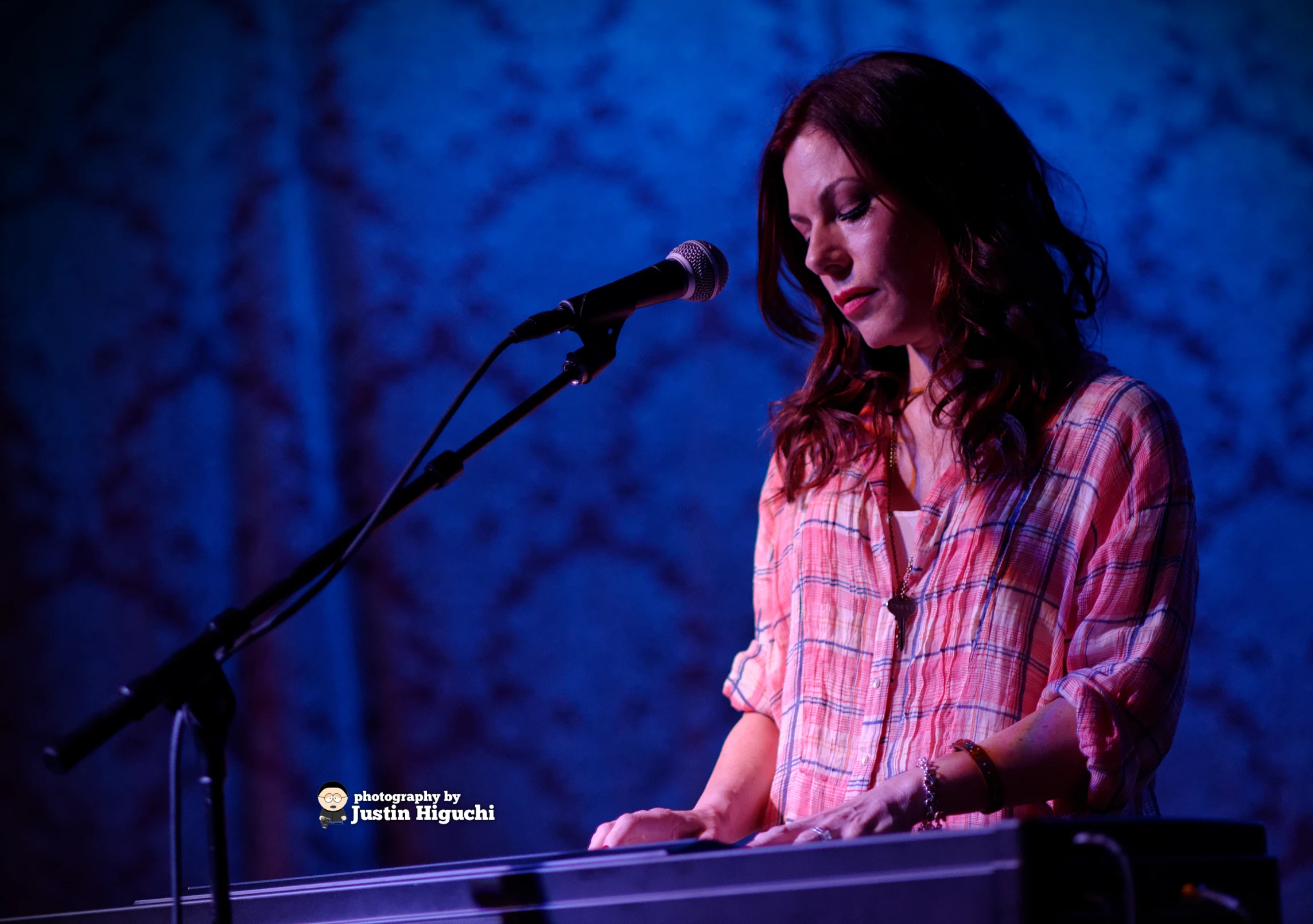 a woman standing at a podium playing keyboards