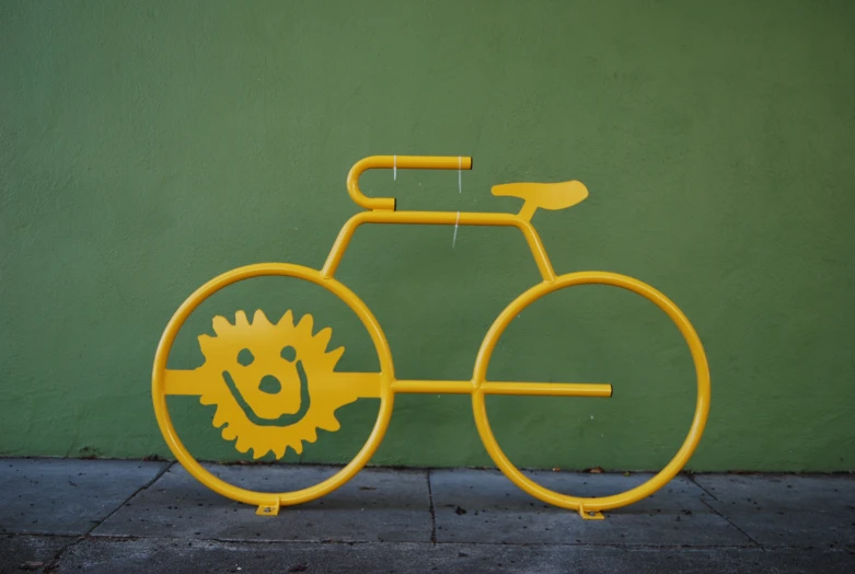 a yellow bike that is on the side of a building
