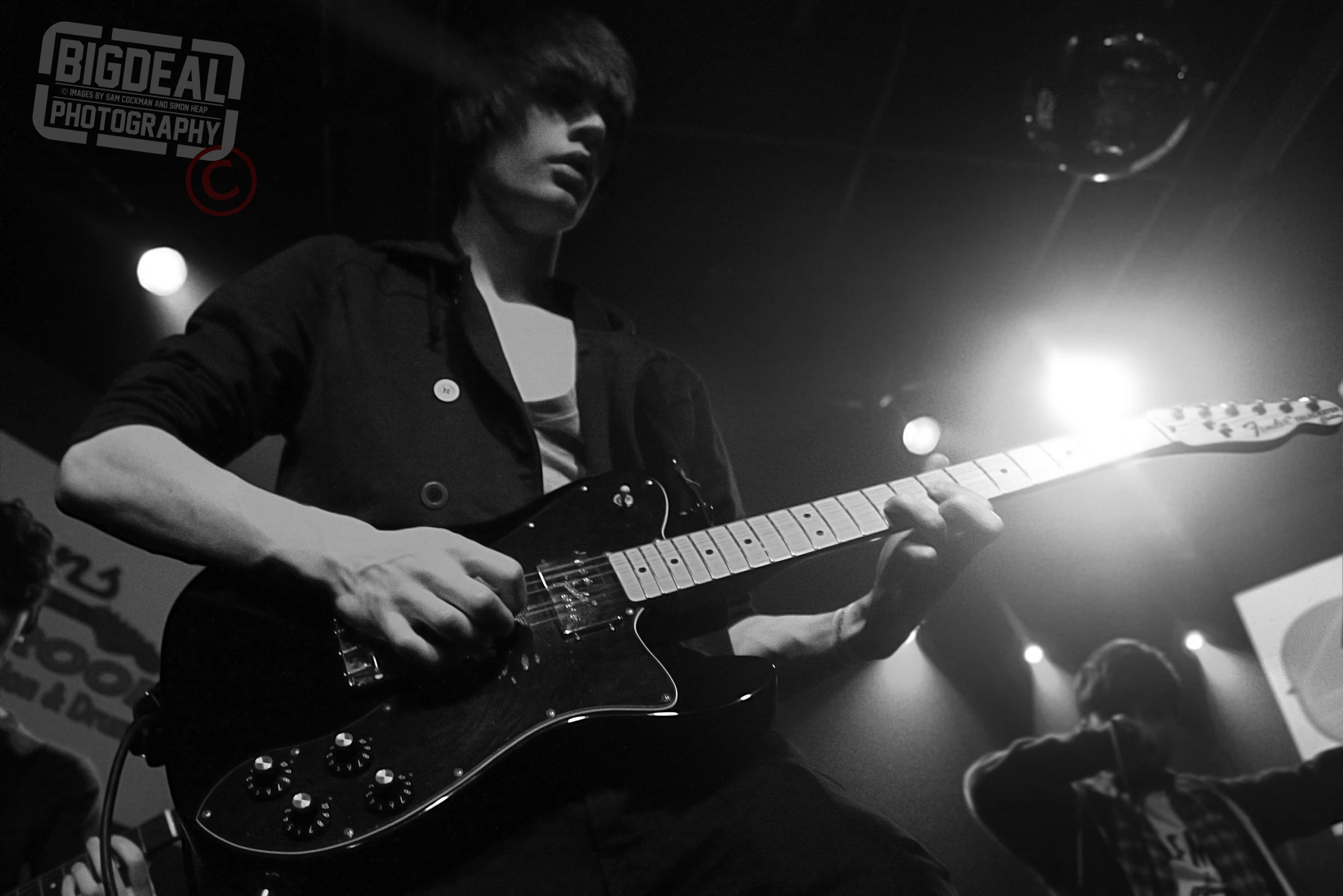 a man plays guitar at the dark and white