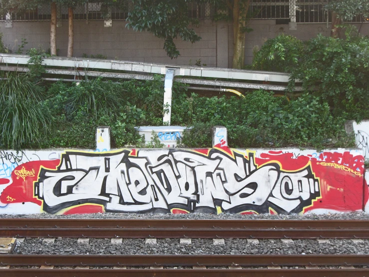 a graffiti covered wall with red letters and white writing