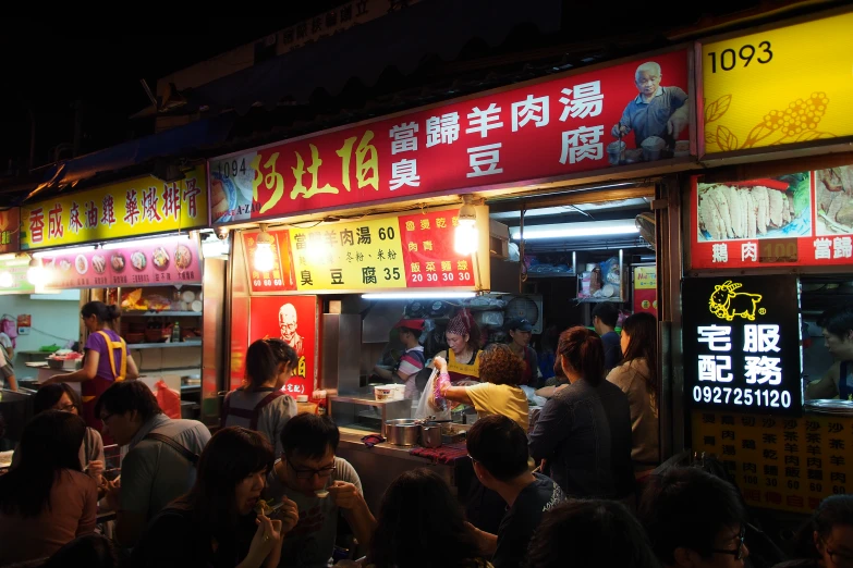 a group of people are standing in front of restaurant signs