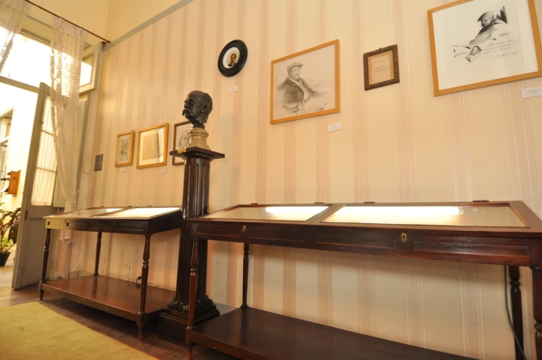 the wooden console table in front of a wall with pictures on it