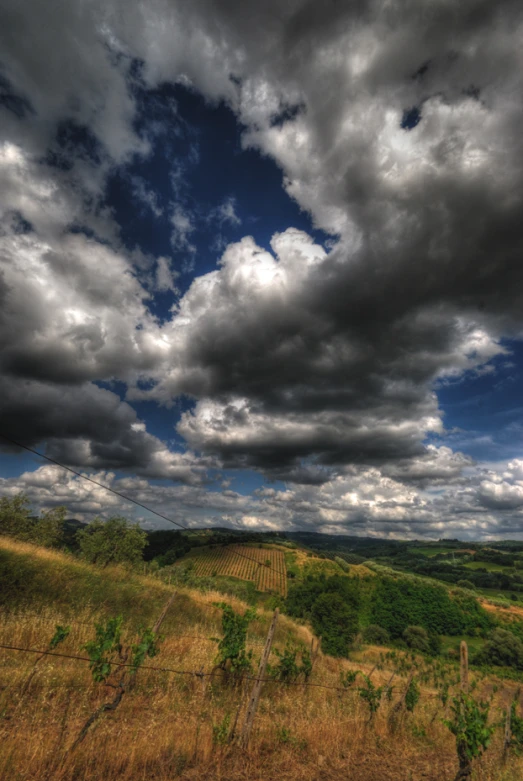 the sky is full of clouds over a field