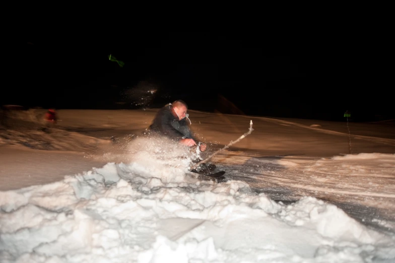 a man in the snow is skiing at night