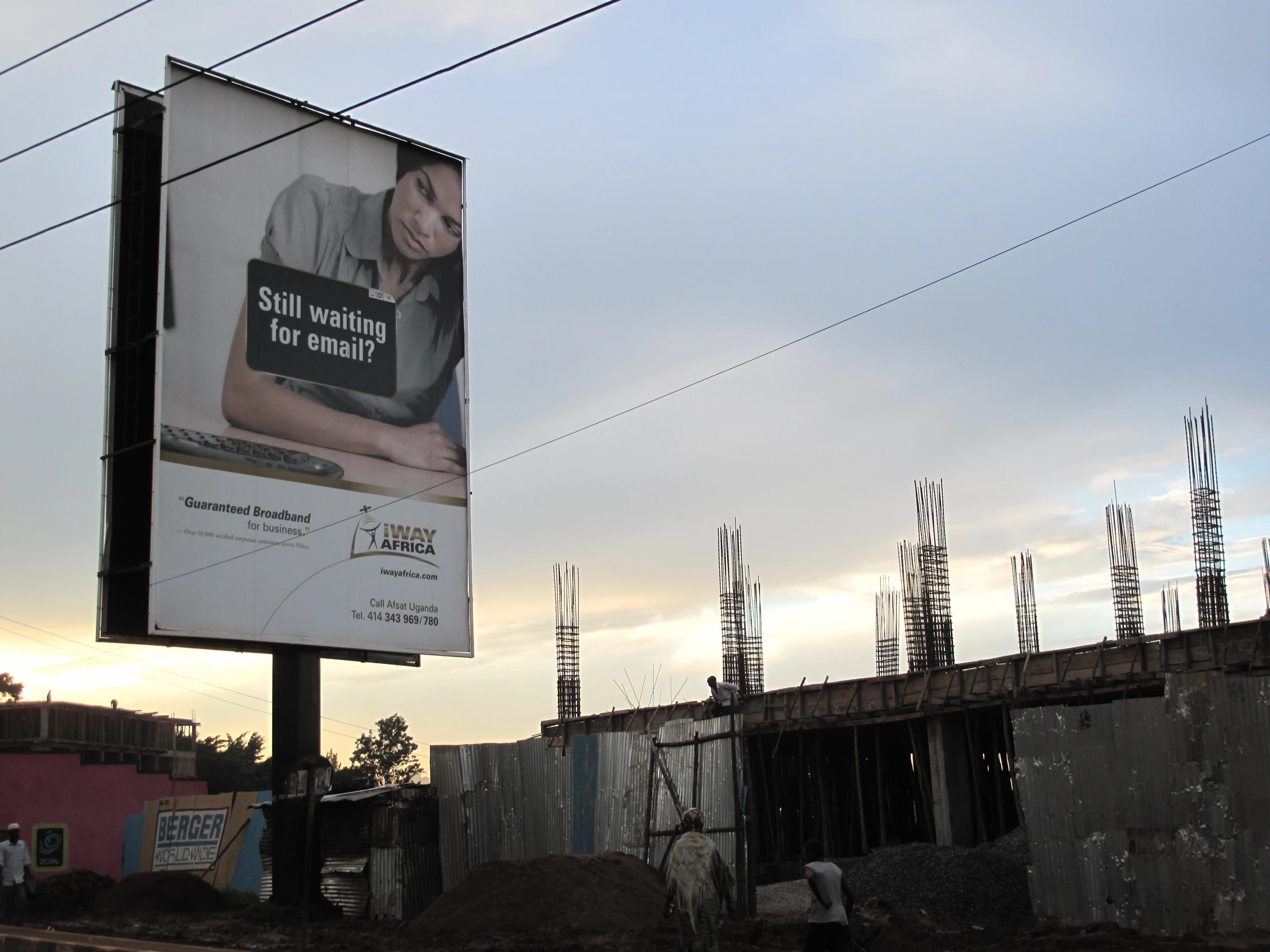 a billboard on a power pole over a dirty field