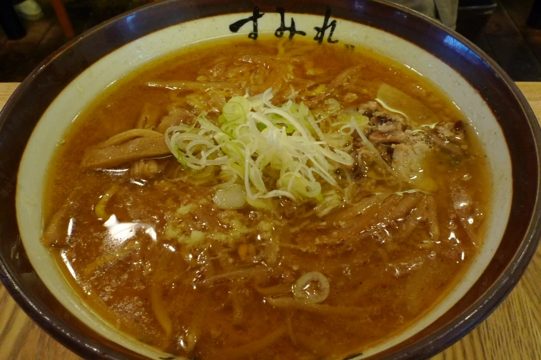 a bowl of noodles and vegetables with rice and meat