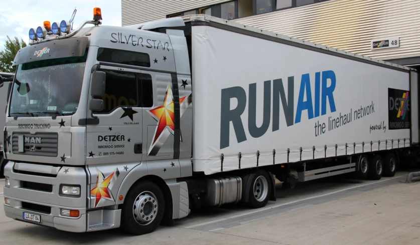 the back of a truck painted with stars is parked in front of a building