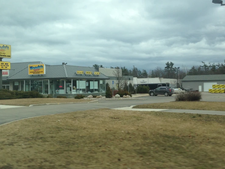 the front of a business with cars parked in the lot
