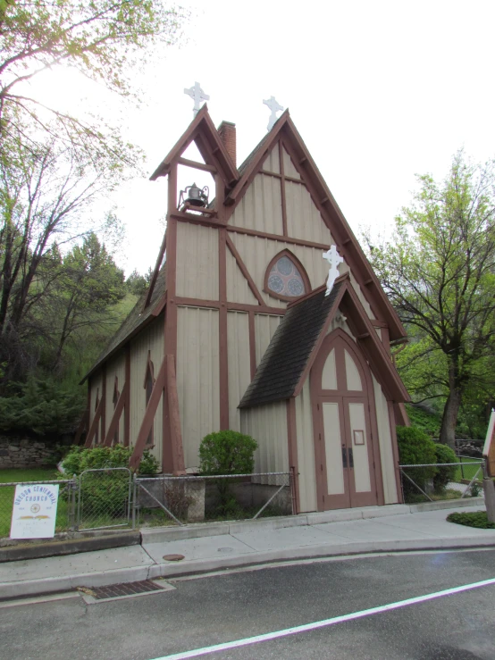 this is an old church built with wooden shingles and has a steeple with a clock