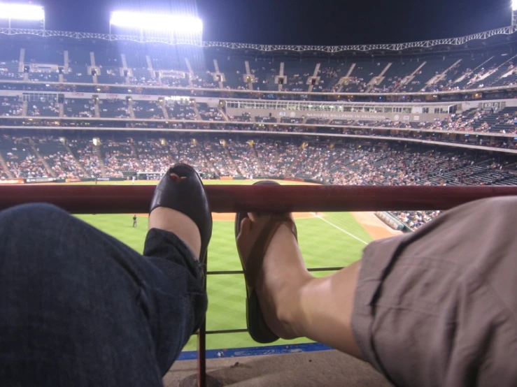 a person is sitting at the stands looking out over a field