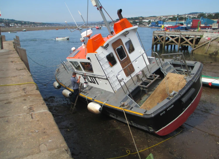 an old red and white boat tied up to the dock