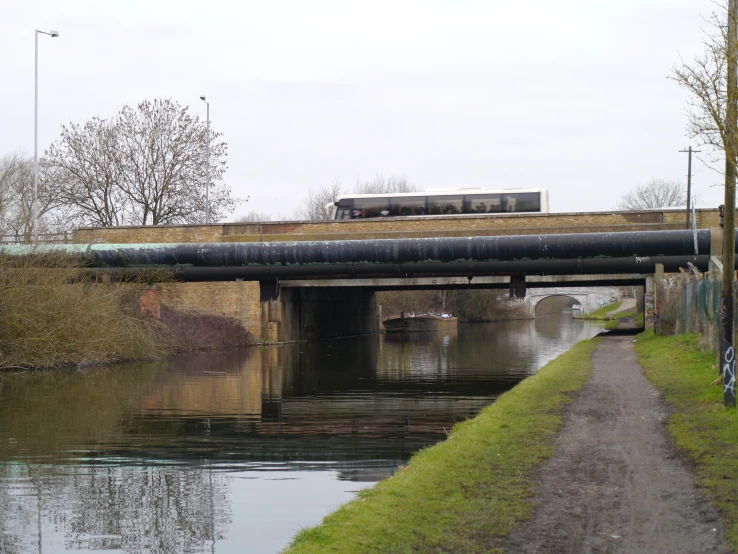 a train passing under a bridge on a river