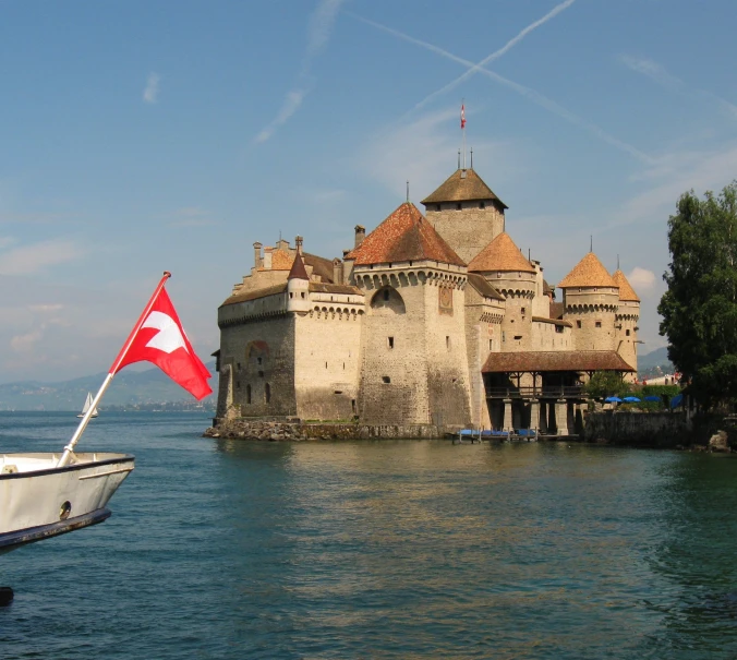 a castle sitting in the middle of a lake with a flag flying