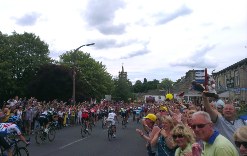 a large group of bicyclists and pedestrians on the road