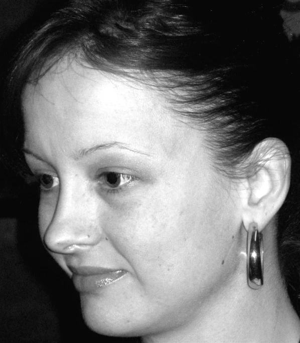 a black and white pograph of a woman wearing large earrings