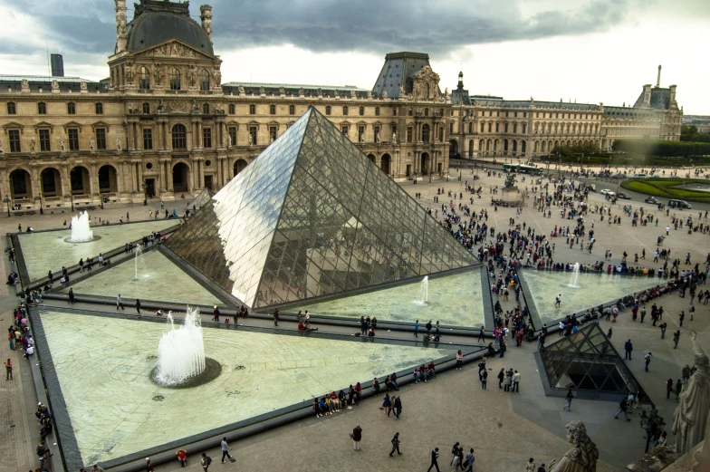 a pyramid in a courtyard with several fountains