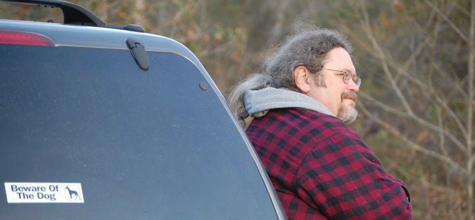 a man with a gray mustache is next to a truck