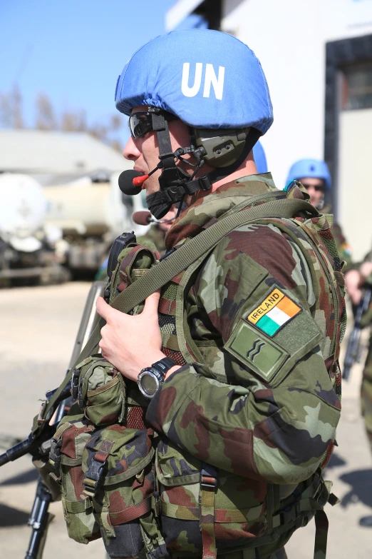 a man in camouflage holds onto an automatic rifle