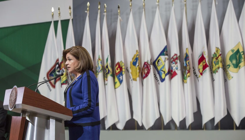 a woman is standing at a podium with an empty microphone