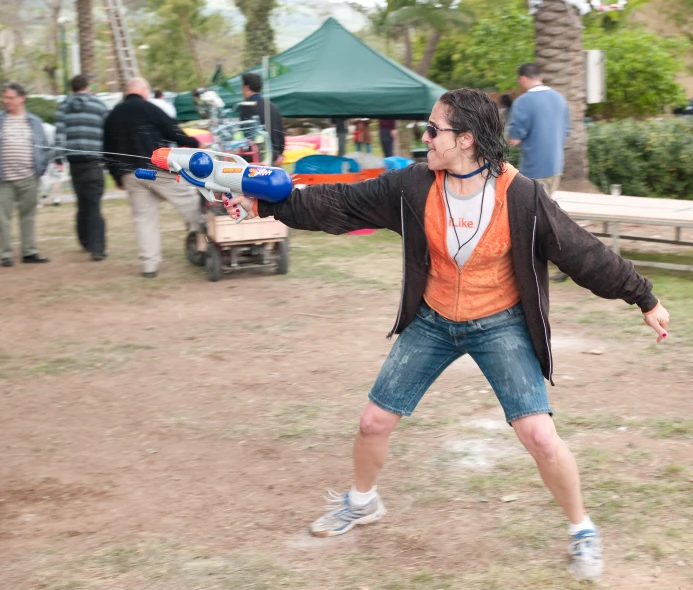 a man stands in a park holding a device