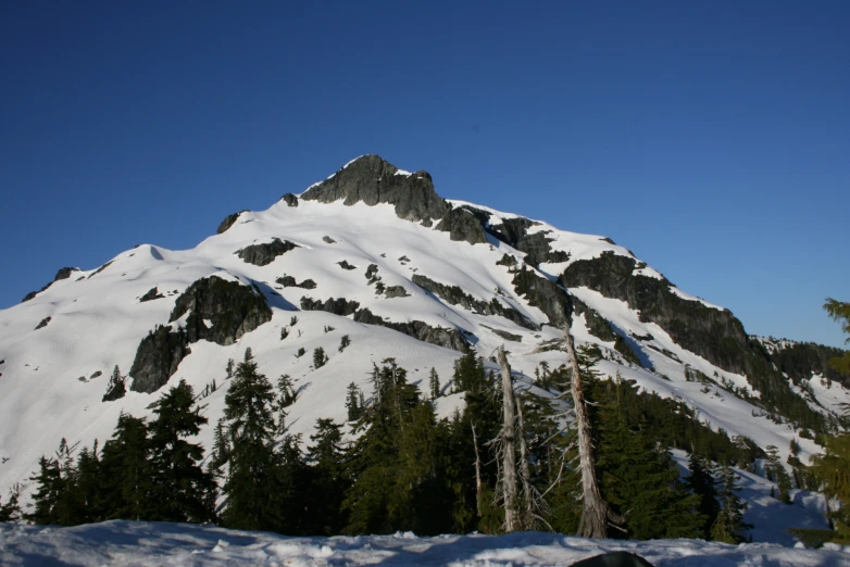 a snowy mountain sits on top of a clear blue sky