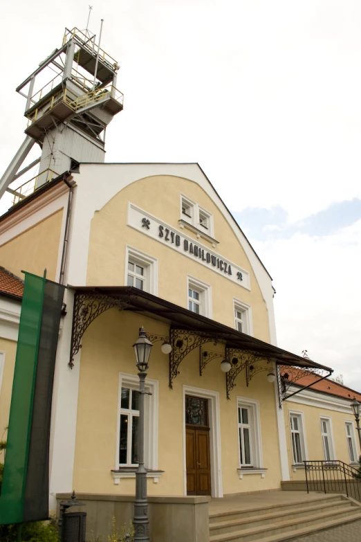 an older style yellow building with stairs in front