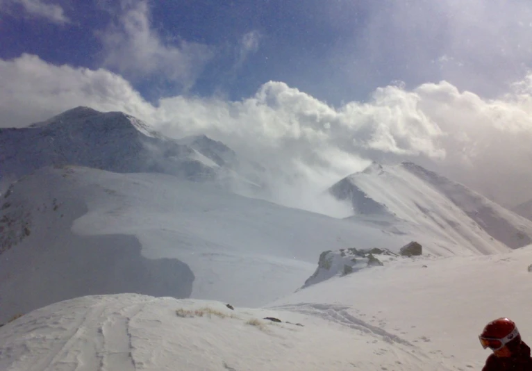 someone on skis standing on snow capped mountain