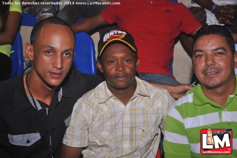 three young men sitting together at an event