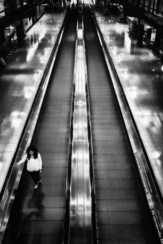 the girl is sitting on the escalator outside in the evening