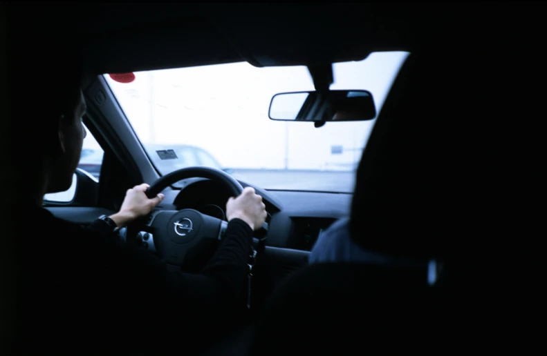 two people sit at the steering wheel in their vehicle