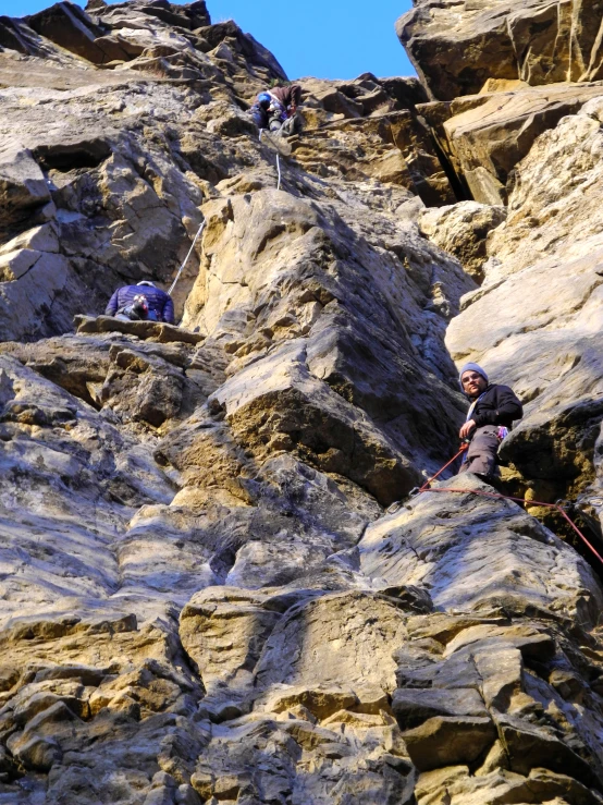 some men climbing on top of rock mountain