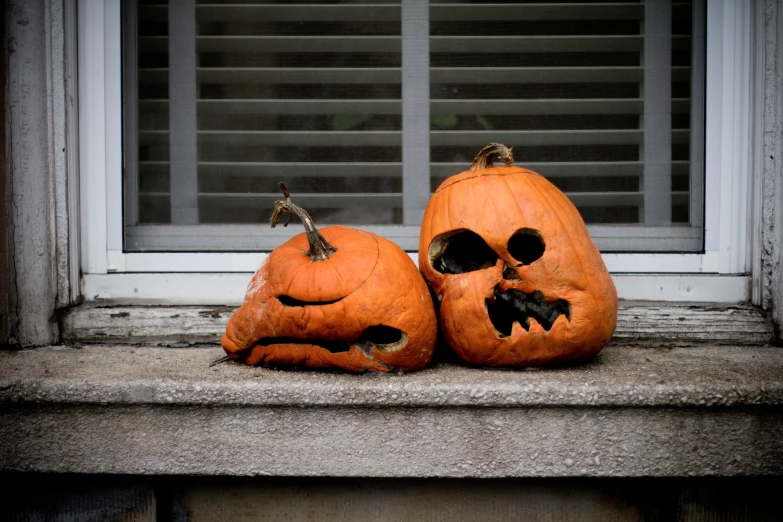 a couple of jack o lantern pumpkins in front of a window