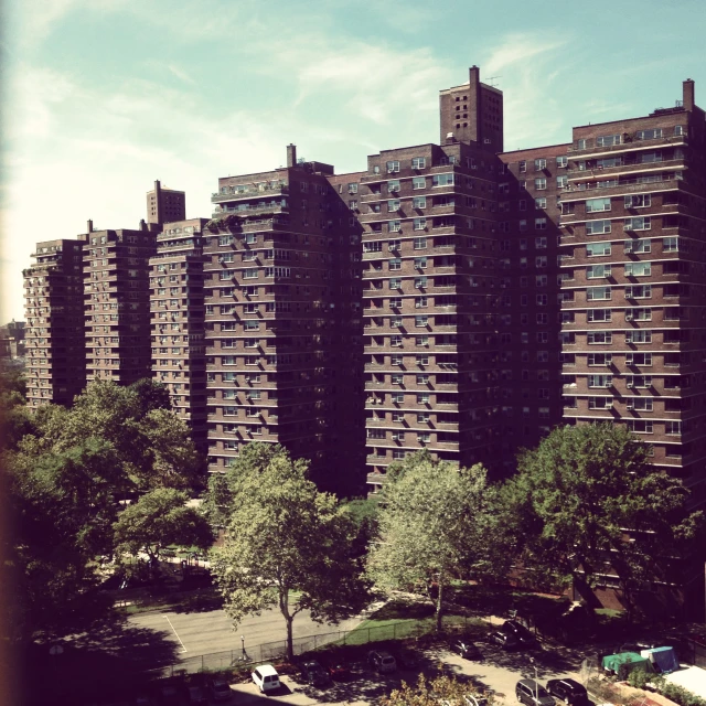 an aerial s of a park next to large brick buildings