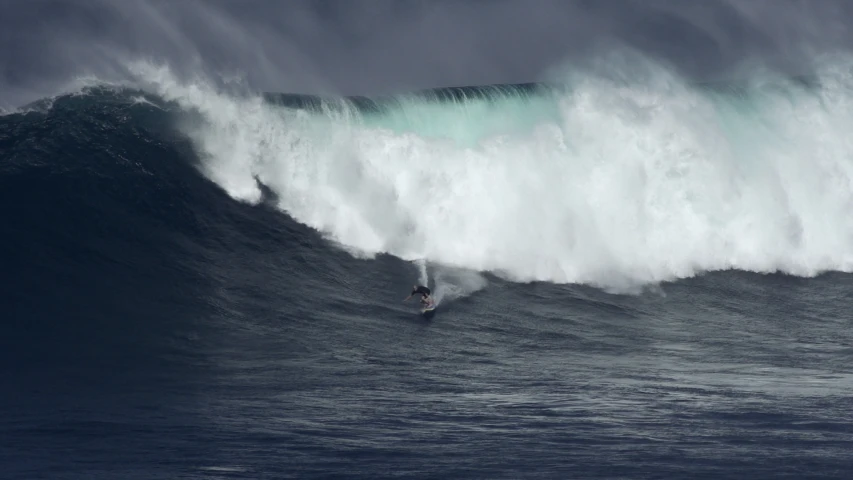 a man riding a surfboard in the middle of a wave