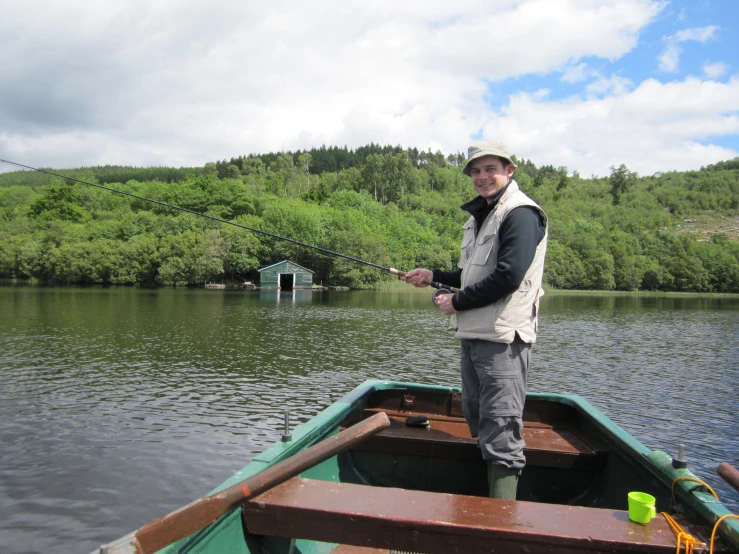 a man standing on a boat fishing in the water