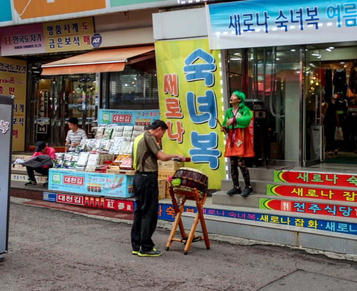 an asian man sells products from a small stall