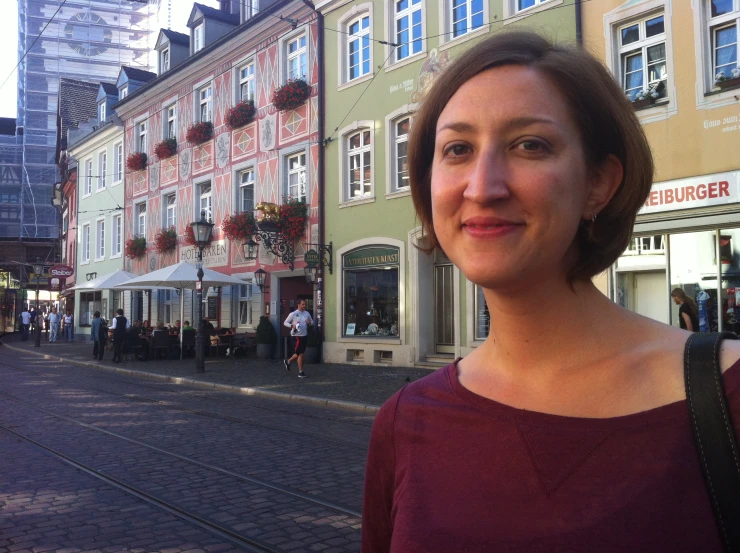 there is a woman that is standing in front of some buildings