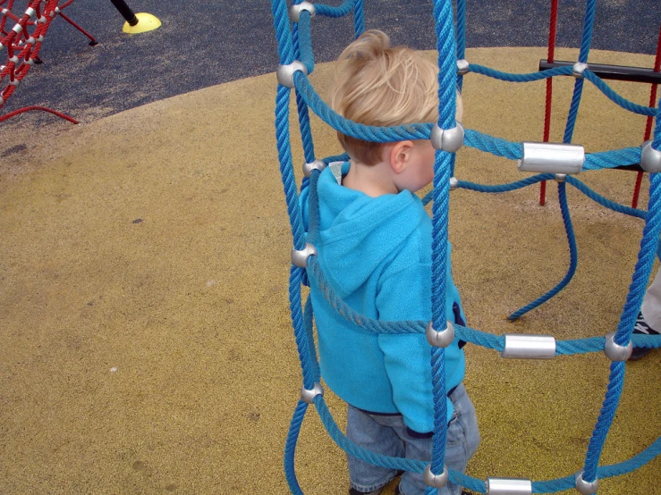 a small child climbing a rope slide with ropes