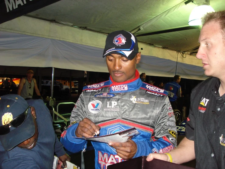 a man in a grey jacket holding a digital device