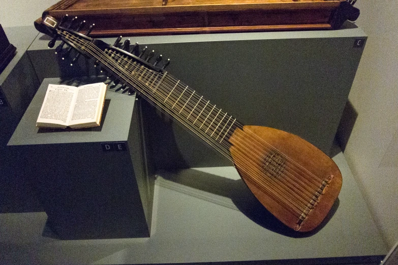 a wooden and metal instrument sitting on display next to an open book
