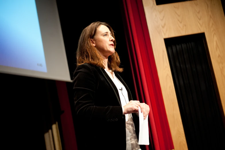 a woman giving a presentation at the end of a lecture