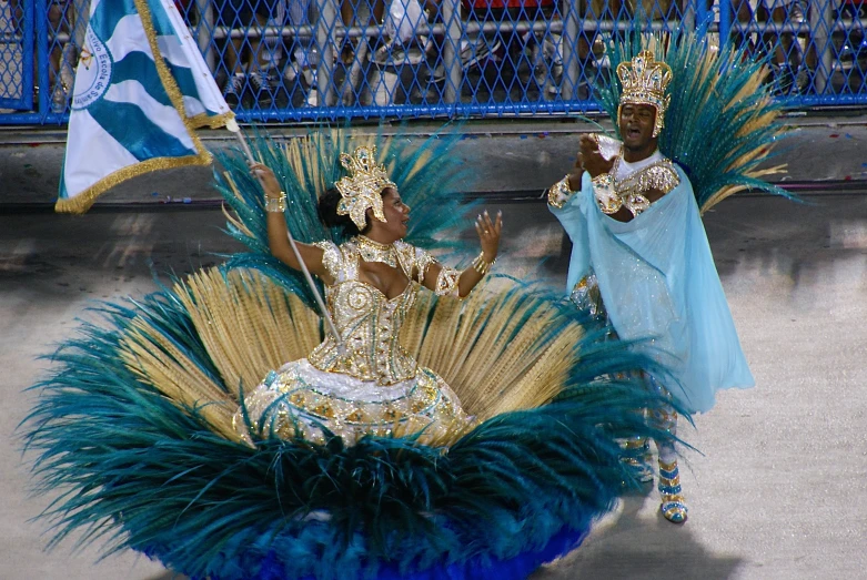 two performers in elaborate costumes with large feathers