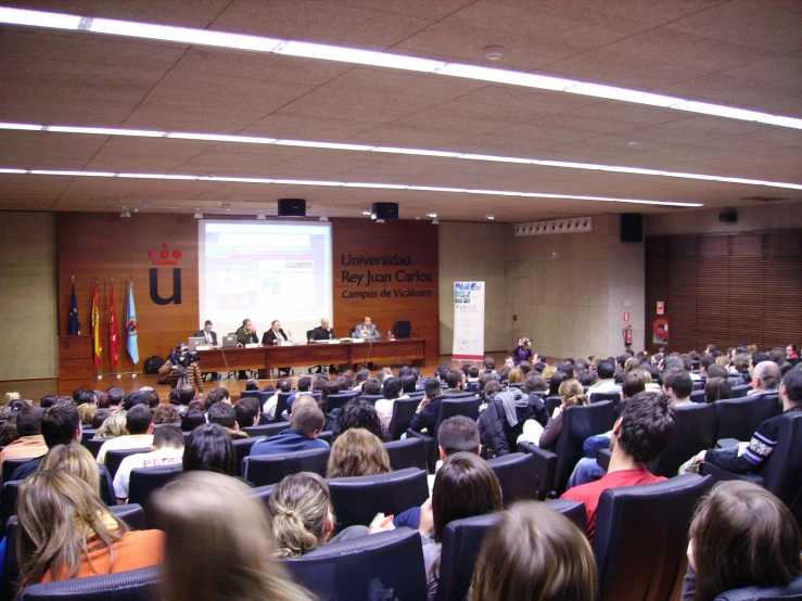 a crowd of people watching a presentation in a lecture hall