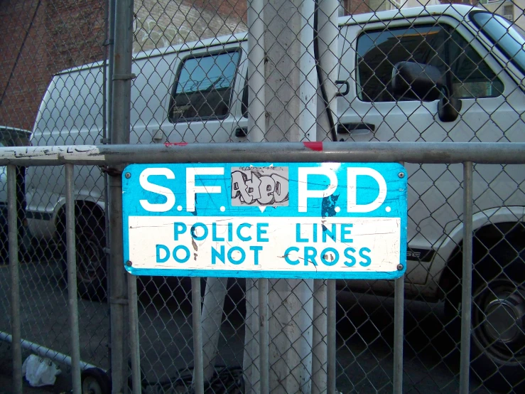 a sign attached to a fence saying do not cross