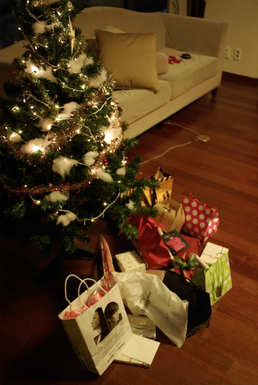 presents under the christmas tree on a hard wood floor