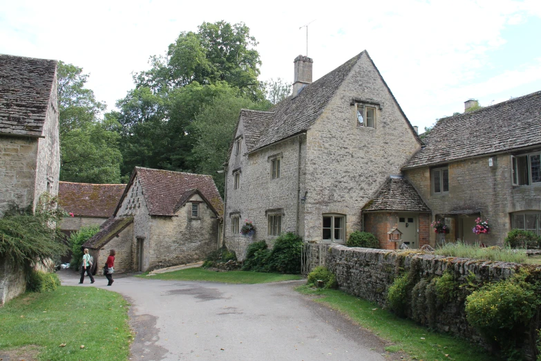 people walking down a path into a village