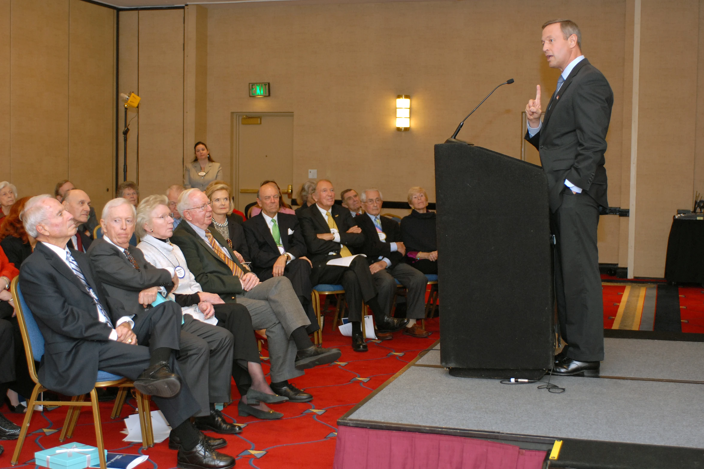 a man standing at a podium while speaking to an audience