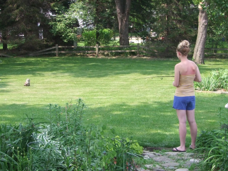 a woman is in her back yard watching birds