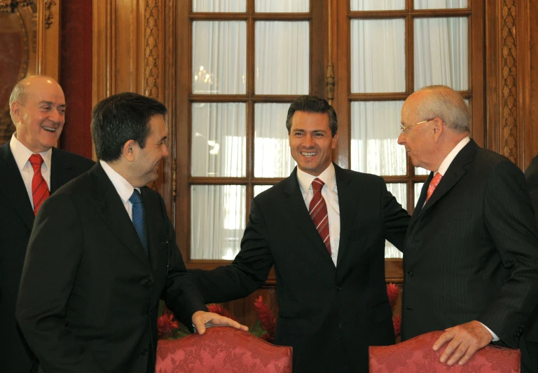 three men in suits standing near each other