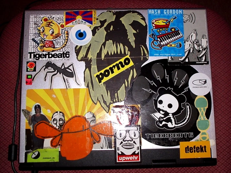 a laptop that has some cartoon stickers on it